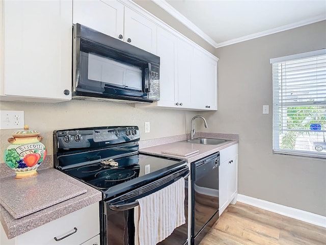 kitchen with white cabinets, ornamental molding, sink, black appliances, and light wood-type flooring