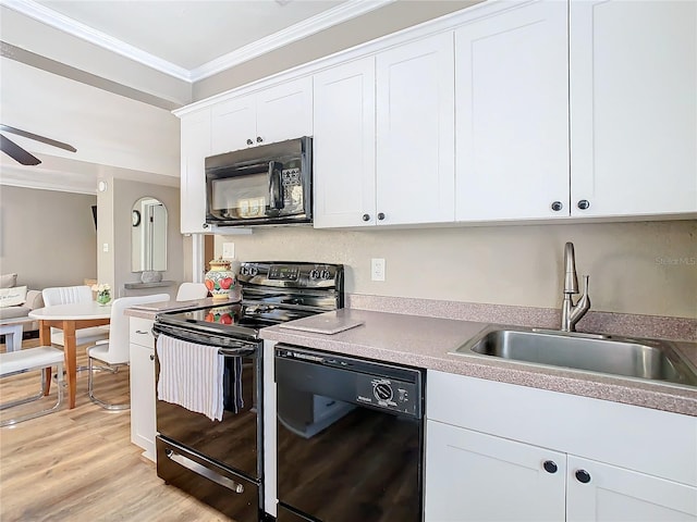 kitchen featuring white cabinets, black appliances, light wood-type flooring, and sink