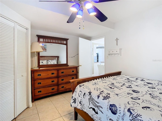 tiled bedroom with ceiling fan and a closet