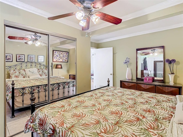 tiled bedroom with ceiling fan, a closet, and ornamental molding