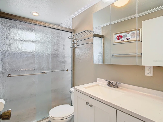 bathroom with a textured ceiling, a shower with door, crown molding, vanity, and toilet