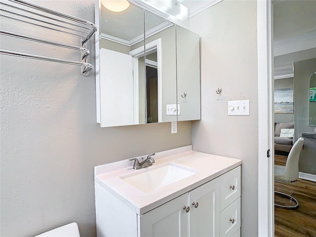 bathroom with ornamental molding, vanity, and hardwood / wood-style floors