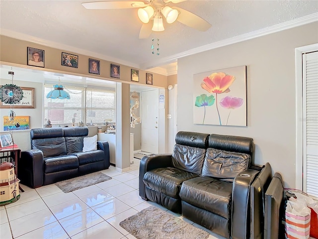 living room with a textured ceiling, light tile patterned floors, ornamental molding, and ceiling fan