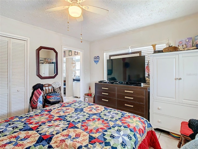 bedroom featuring a closet, ceiling fan, light tile patterned floors, and a textured ceiling