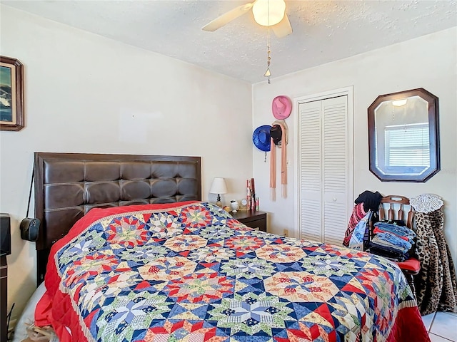 bedroom with ceiling fan, a textured ceiling, and a closet