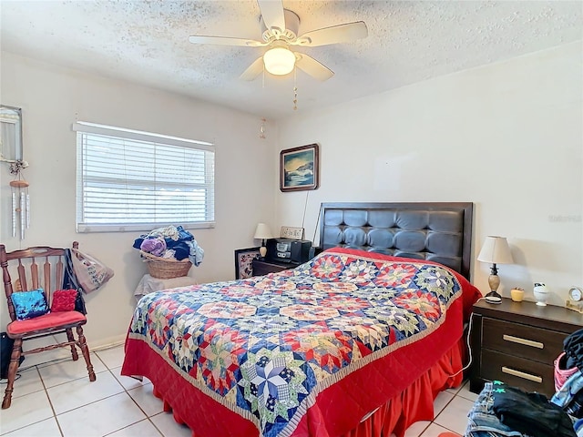 bedroom featuring a textured ceiling, light tile patterned floors, and ceiling fan