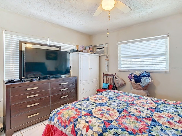 tiled bedroom with ceiling fan and a textured ceiling