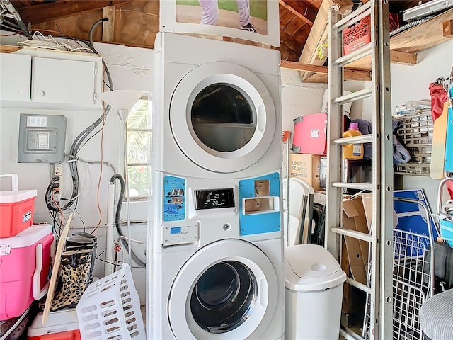 clothes washing area featuring stacked washing maching and dryer