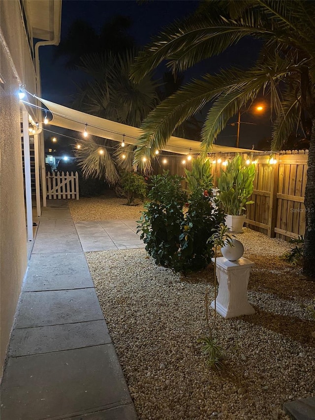 yard at night with a patio area