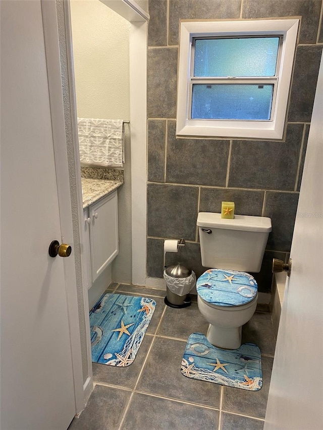 bathroom with vanity, tile walls, toilet, and tile patterned floors