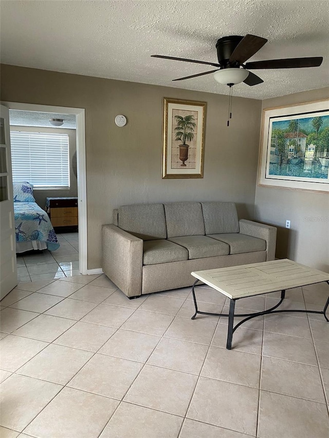 tiled living room with ceiling fan and a textured ceiling