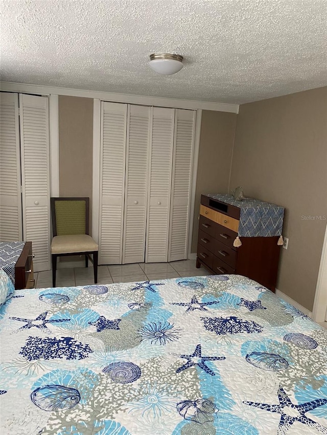 bedroom with a textured ceiling and light tile patterned floors