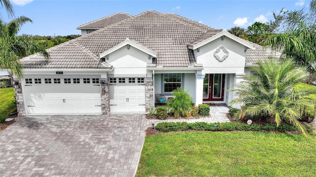 view of front of property with stucco siding, a garage, and a tiled roof