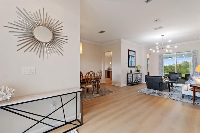 interior space with visible vents, crown molding, baseboards, light wood-style flooring, and a notable chandelier