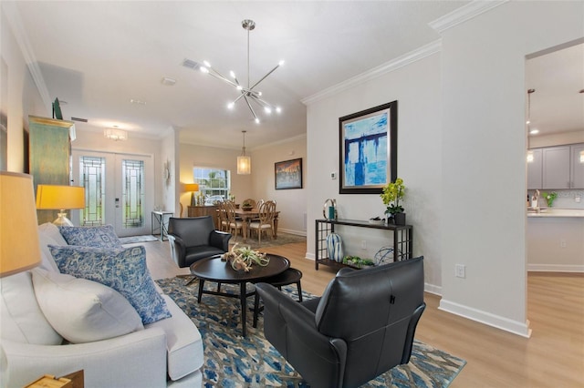 living room featuring a notable chandelier, crown molding, and light hardwood / wood-style flooring