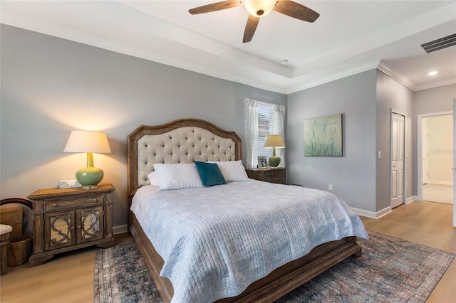 bedroom featuring ceiling fan, ornamental molding, ensuite bathroom, and light hardwood / wood-style flooring