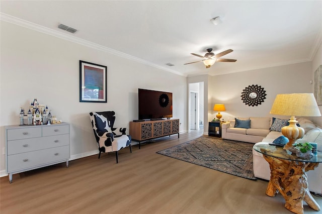 living room featuring ceiling fan, ornamental molding, and wood-type flooring