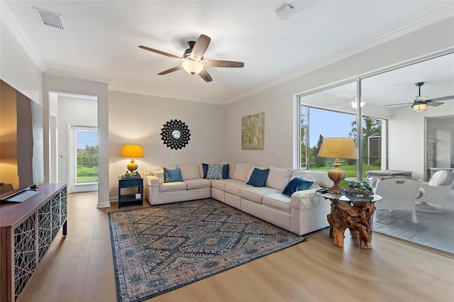 living room featuring ornamental molding, hardwood / wood-style flooring, and ceiling fan