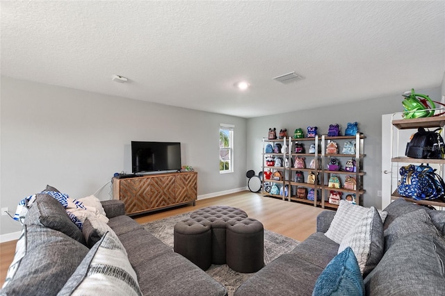 living room featuring a textured ceiling and light hardwood / wood-style flooring