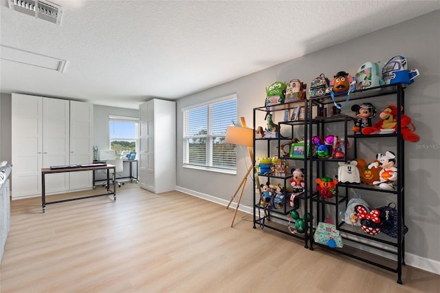 misc room featuring a textured ceiling and light hardwood / wood-style floors