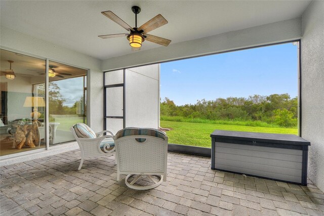 sunroom / solarium with a healthy amount of sunlight and ceiling fan