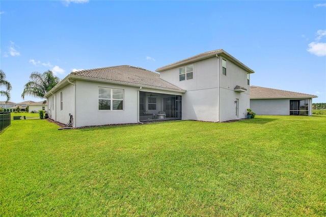 rear view of property with a yard and a sunroom