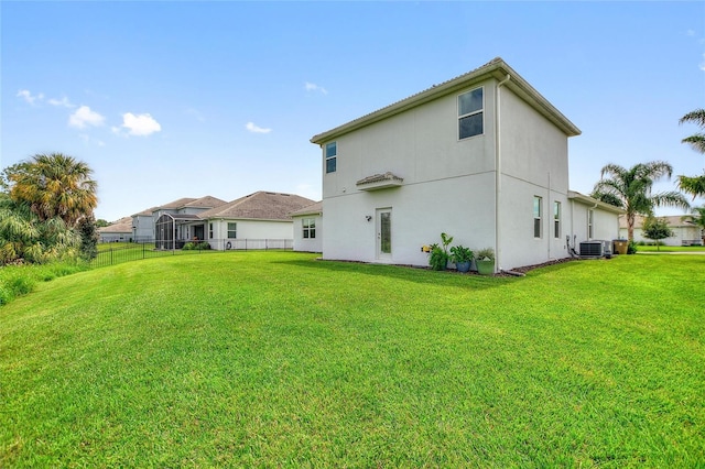 back of property featuring a lawn and central air condition unit