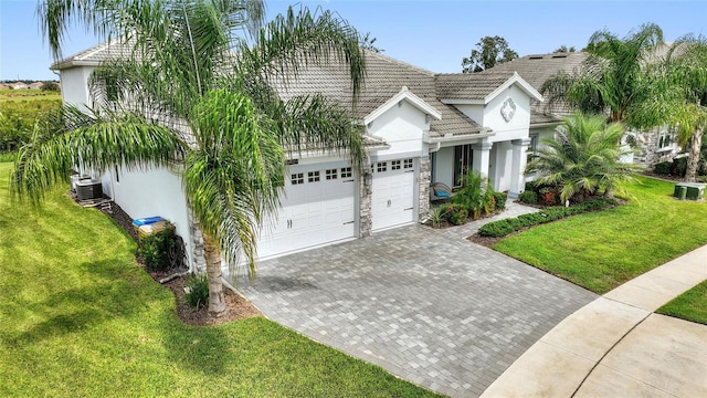 view of front of house with a garage, a front lawn, and central AC