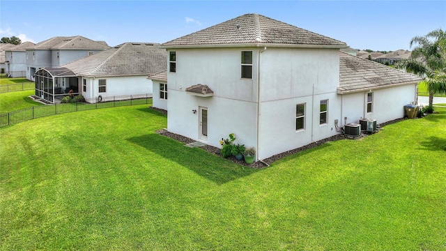 back of property featuring central AC unit and a yard