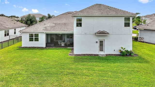 back of property featuring a sunroom and a lawn