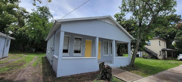 view of front of house with a porch and a front lawn