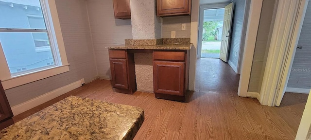 kitchen with light hardwood / wood-style flooring and light stone counters