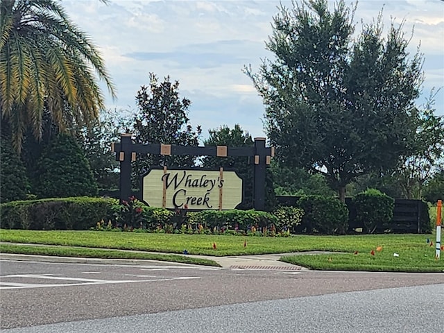 community sign featuring a yard