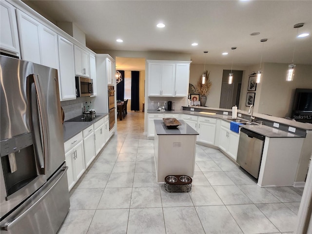 kitchen featuring sink, stainless steel appliances, kitchen peninsula, hanging light fixtures, and white cabinets