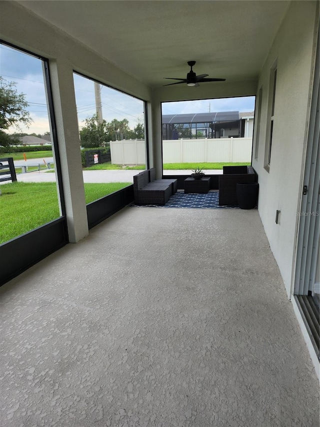 unfurnished sunroom with ceiling fan