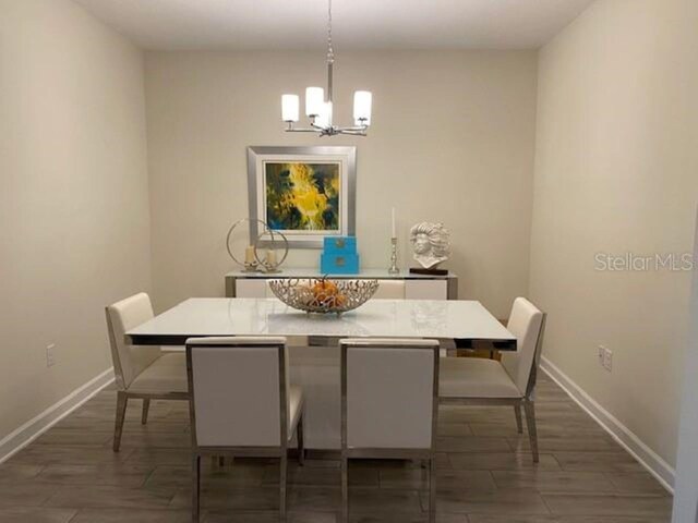 dining space with a chandelier and dark hardwood / wood-style flooring