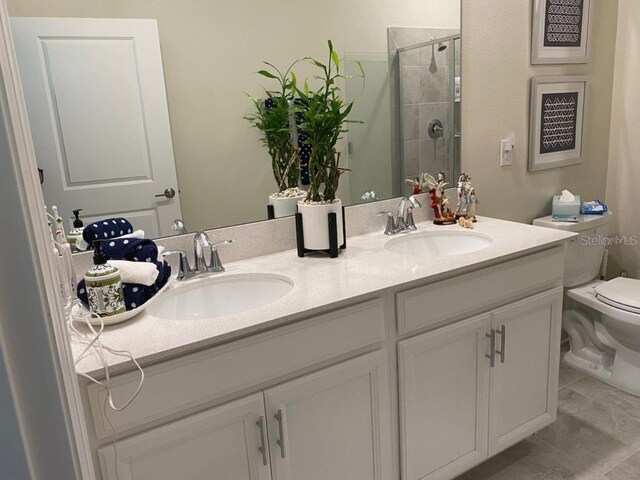 bathroom with tile patterned flooring, vanity, toilet, and a shower with shower door