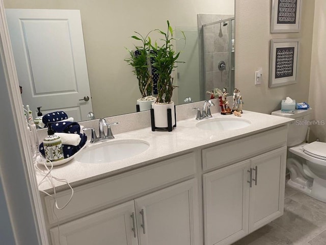 bathroom with a sink, toilet, double vanity, and a shower stall