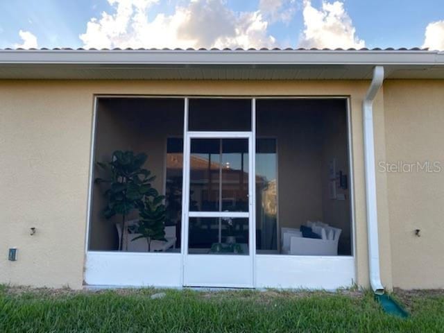 view of property exterior featuring stucco siding and a sunroom