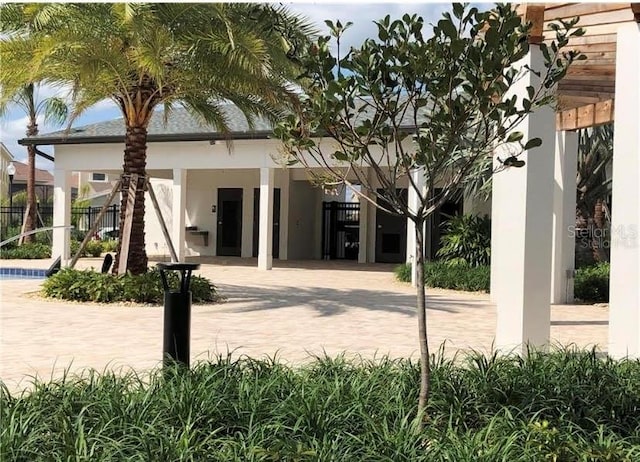 back of house featuring stucco siding and fence