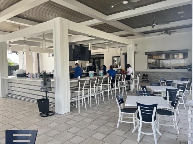 view of patio featuring outdoor dining space, ceiling fan, visible vents, and outdoor dry bar