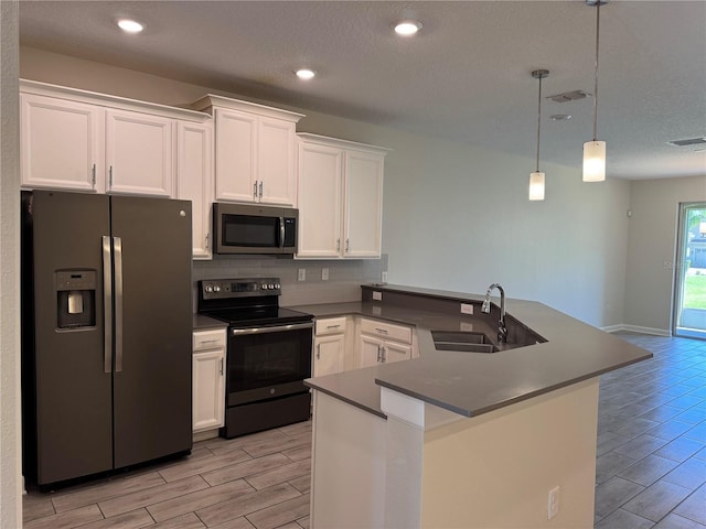 1077 Quaker Ridge Ln, Davenport, FL 33896 - kitchen with a peninsula, a sink, tasteful backsplash, wood finish floors, and appliances with stainless steel finishes