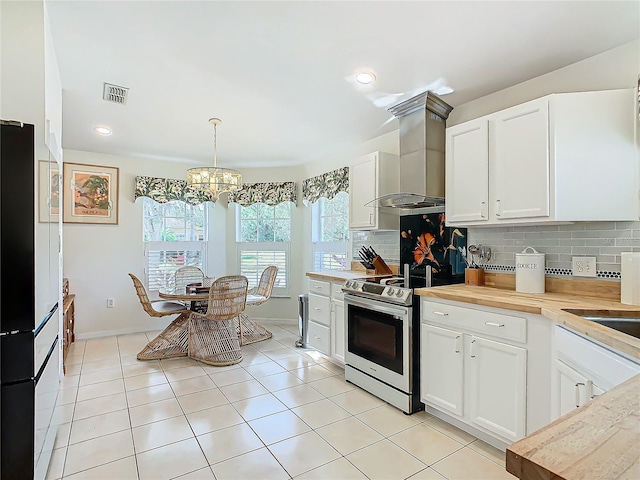 205 Bell Tower Xing W, Kissimmee, FL 34759 - kitchen featuring stainless steel electric range oven, wall chimney range hood, tasteful backsplash, a chandelier, and freestanding refrigerator