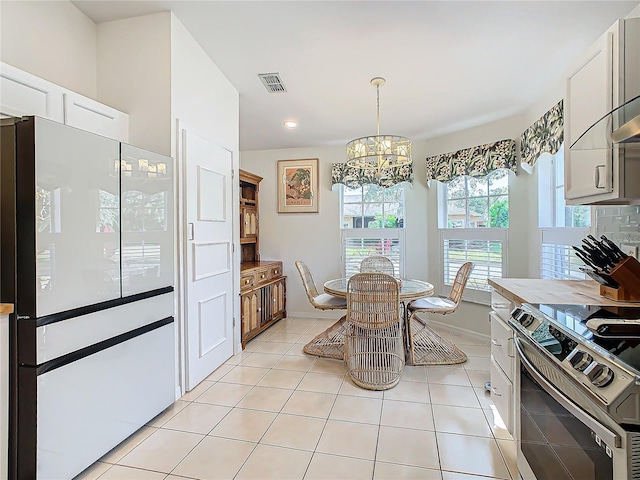 205 Bell Tower Xing W, Kissimmee, FL 34759 - kitchen featuring electric range, a chandelier, light tile patterned flooring, freestanding refrigerator, and white cabinets