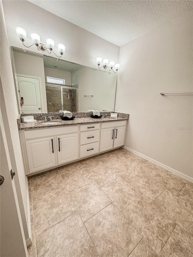 bathroom with a textured ceiling, vanity, an enclosed shower, and tile patterned floors