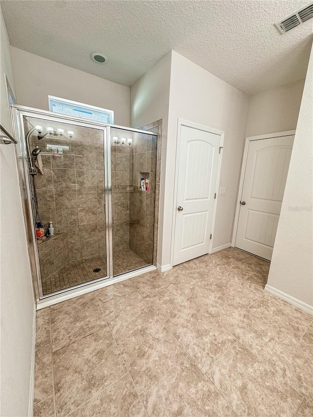 bathroom with walk in shower and a textured ceiling