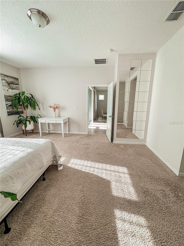 bedroom with a textured ceiling and carpet flooring