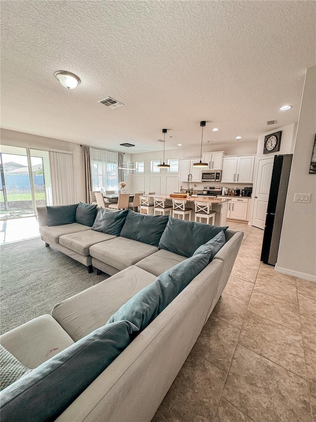 living room featuring a textured ceiling and light tile patterned flooring