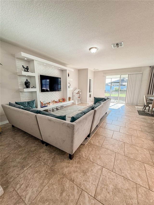 tiled living room featuring a textured ceiling