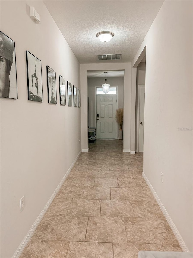 hall with a textured ceiling